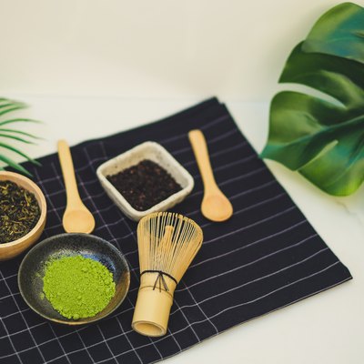 matcha green tea benefits and bamboo whisk on white background. tradition japanese tea ceremonial.