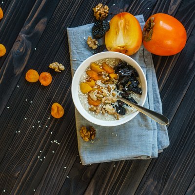 Oatmeal with Persimmon on a Black Wooden Table