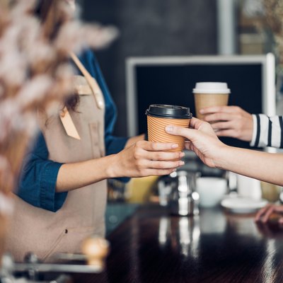 Barista served take away hot coffee cup to customer at counter bar in cafe restaurant,coffee shop business owner concept,Service mind waitress.