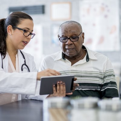 A doctor showing a patient his test results on a tablet computer