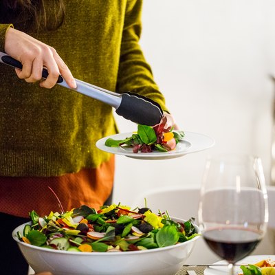 Woman serving salad while standing during party