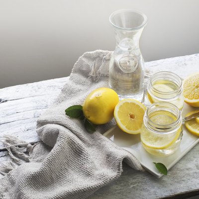 Lemon water on white wooden table. Still life.