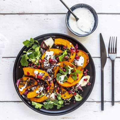 Autumnal salad with fried pumpkin, lentils, radicchio, pomegranate seeds, leaf salad and parsley with dressing