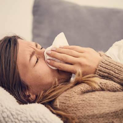 Sick woman with seasonal infections, flu, allergy lying in bed.