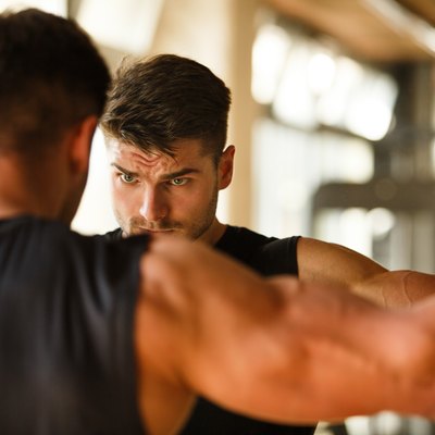 man flexing at the gym measuring muscle mass