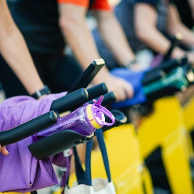 People Exercising On Exercise Bike At Gym