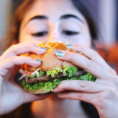 Close-Up Of Woman Eating Burger