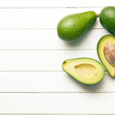 halved avocados on wooden background