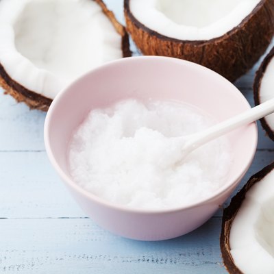 Homemade coconut oil in jar with fresh coco. Organic cosmetic for body care, beauty and spa.