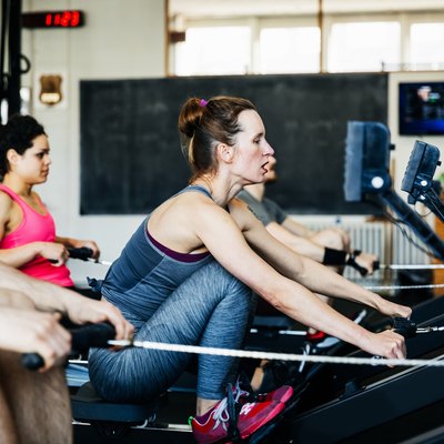 Fitness Team Using Rowing Machines Together