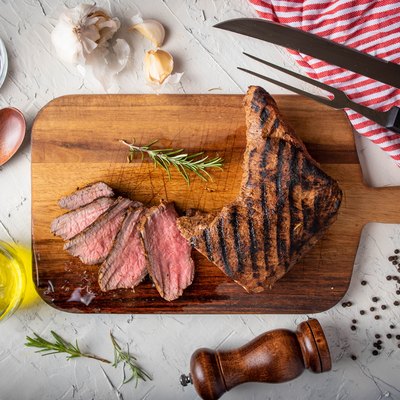 sliced tri tip seak marinated with santa maria sauce on wooden cutting board