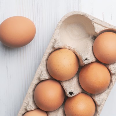fresh eggs in paper tray on white surface b