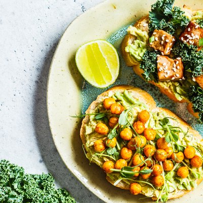 Vegan open sandwiches for bone health with guacamole, tofu, chickpeas and sprouts on a plate.