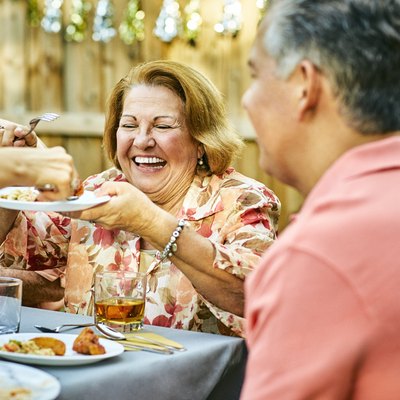 Cheerful family eating at table in back yard