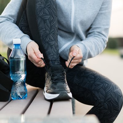 Shot of athletic woman tying she is shoelaces before a run.