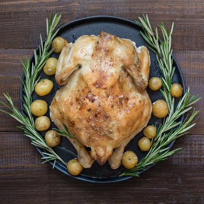 Traditional roasted turkey with rosemary on wooden table. Top view. Thanksgiving day.