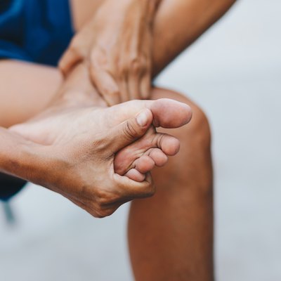 Closeup young woman feeling pain in her foot , Healthcare and medical concept