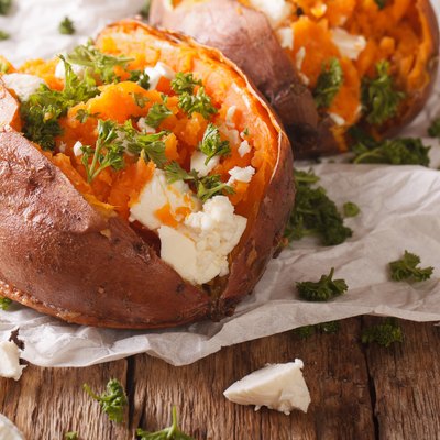 healthy food: baked sweet potato stuffed with cheese and parsley close-up. Horizontal