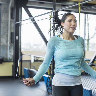 Woman doing a HIIT cardio workout in the gym with a jump rope