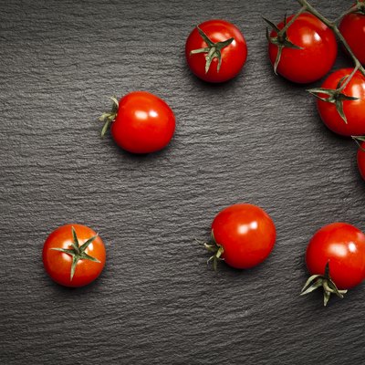 Tomatoes on black stone background