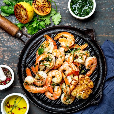 Grilled shrimps prawns on vintage grill pan, top view. Dark background