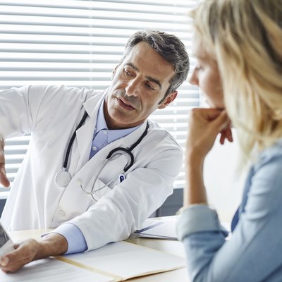 Doctor showing cholesterol levels to female patient