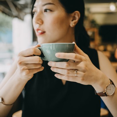 Beautiful young woman enjoying coffee in cafe