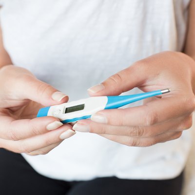 Sick woman measuring body temperature