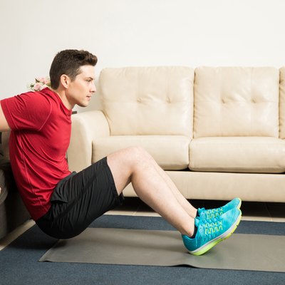 Man doing tricep dips using a couch at home