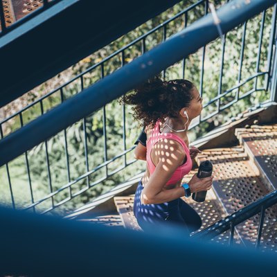Sports Woman running up a staircase