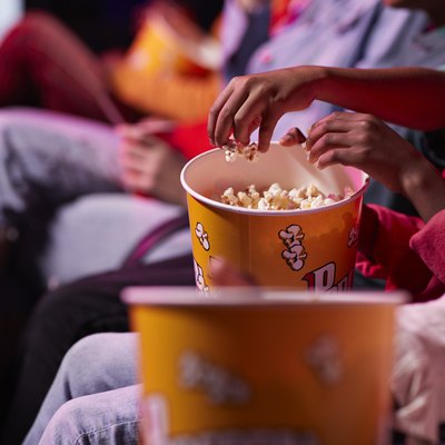movie theater popcorn calories friends sharing popcorn while sitting in theater