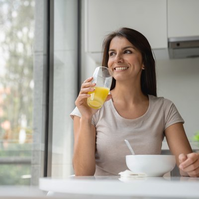 Happy woman having breakfast at home