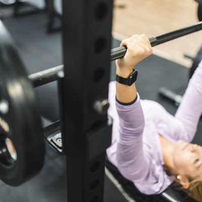 Young woman exercising on the bench press