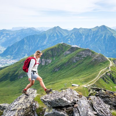 Woman hiking on mountain path above Gastein, Salzburg, Austria