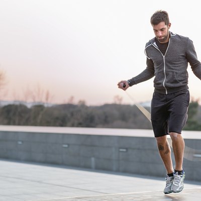 Mid adult man, outdoors, skipping with skipping rope