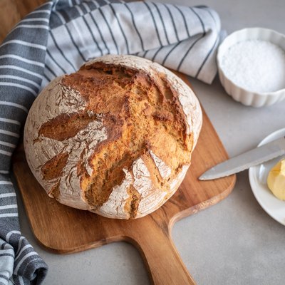Loaf bread on a chopping board with butter