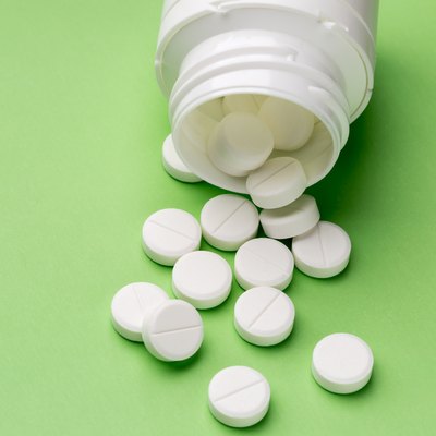 Round white pills and plastic pill bottle