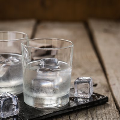 Vodka in shot glasses on rustic wood background