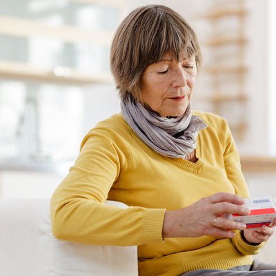 Senior woman reading label on medicine