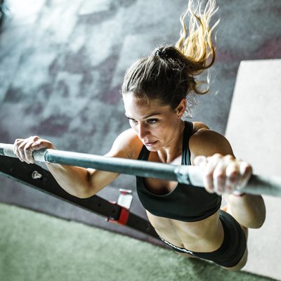 Above view of athletic woman exercising chin-ups in a gym.