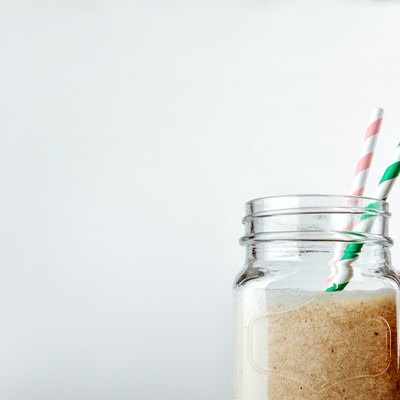 Protein cocktail with milk, vanilla in a glass jar with straws. Sports nutrition