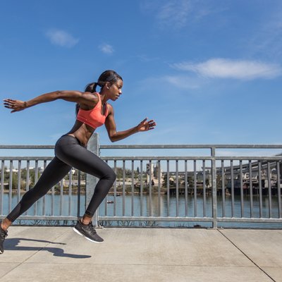 Attractive ethnic female sprinter training in the city