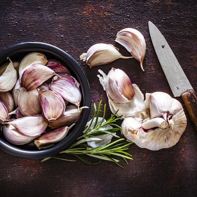 Garlic bulb and cloves shot from above on rustic brown background