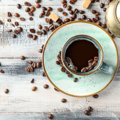 Composition with cup of hot coffee on wooden table