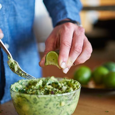 adding lime juice to guacamole