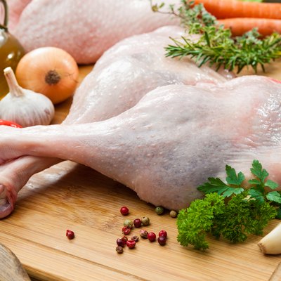 Raw turkey legs on cutting board