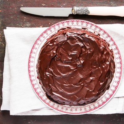 Homemade chocolate truffle brownie cake with chocolate cream spread on a plate on a wooden table. Sweet food. Easter cake.