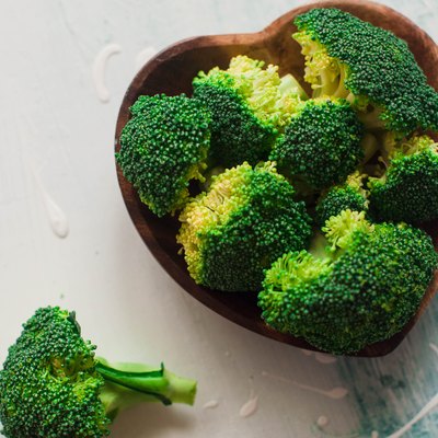 Chopped broccoli on a wooden heart-shaped bowl