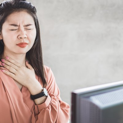 Asian woman suffering from acid reflux or heartburn