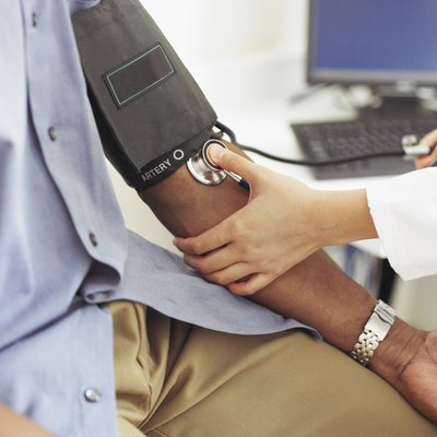 Female doctor taking patient's blood pressure